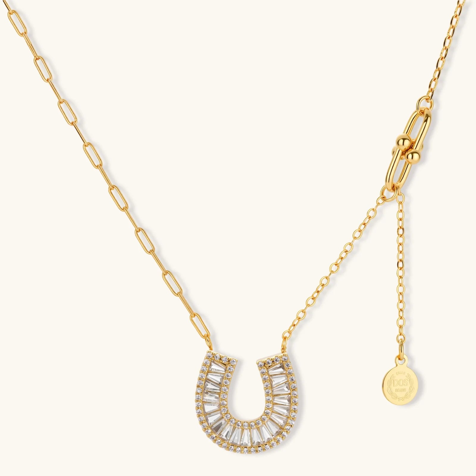 Sparkling horseshoe-shaped jewelry set with AAA cubic zirconia in gold-plated and white gold finishes on cream background.