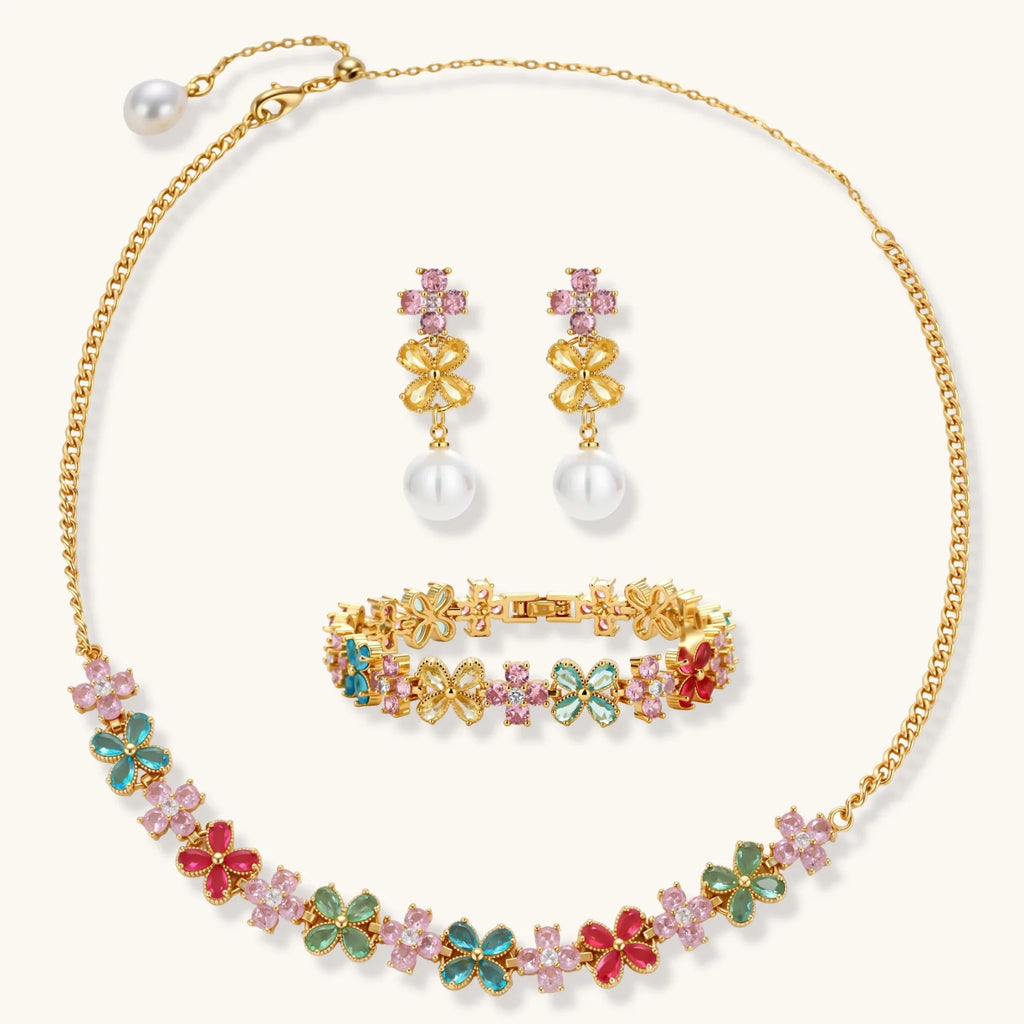 Gold-plated jewelry set with pink, turquoise and red flower-shaped cubic zirconia stones, featuring necklace, earrings and bracelet.