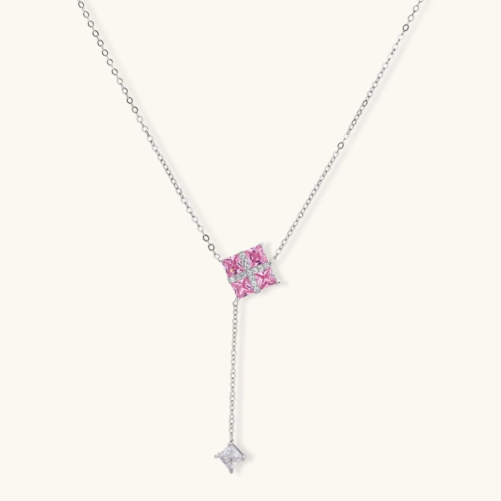 White gold plated jewelry set with pink cubic zirconia stones in geometric cross design, featuring Y-necklace and square stud earrings