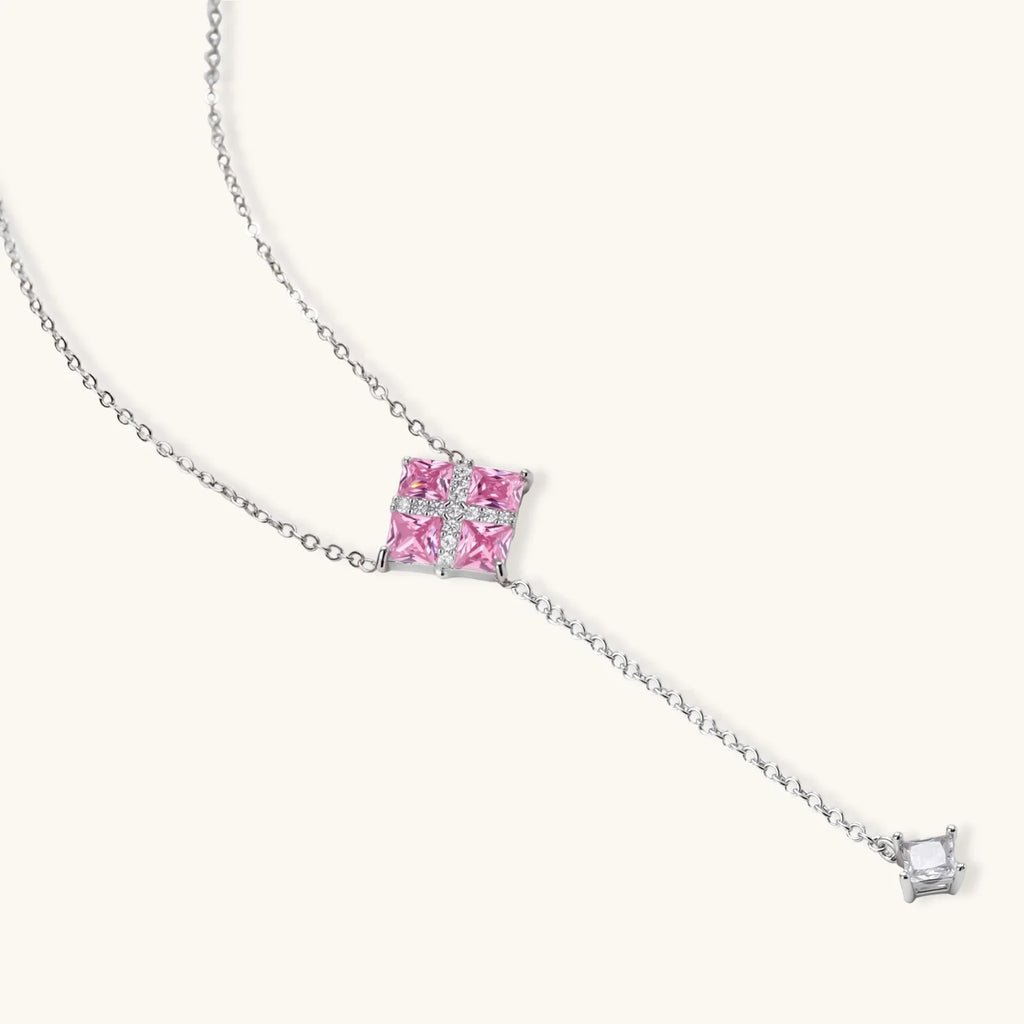 White gold plated jewelry set with pink cubic zirconia stones in geometric cross design, featuring Y-necklace and square stud earrings